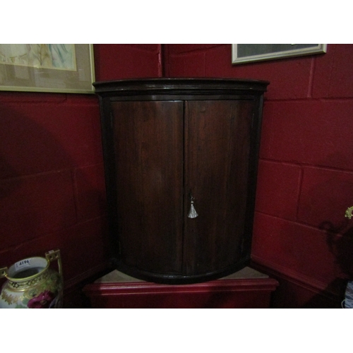 4108 - A George III provincial oak bow-front two door corner cupboard with painted interior and working key... 