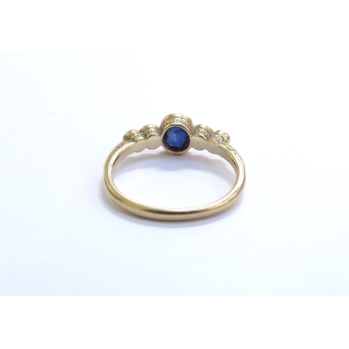 6305 - A sapphire and pearl ring, the central oval sapphire flanked by two graduating pearls in rub over se... 