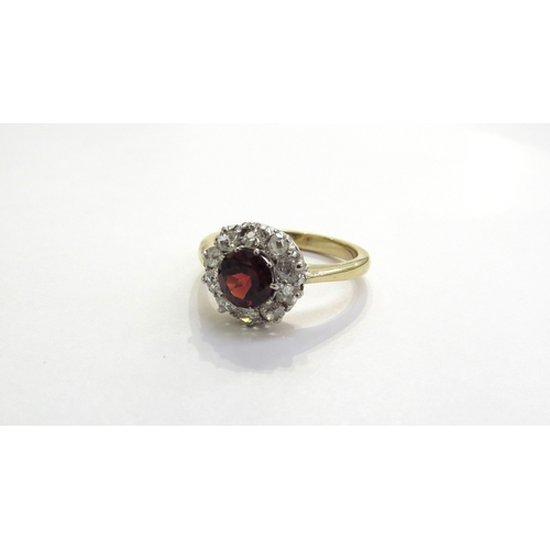 6302 - An 18ct gold garnet and diamond cluster ring the central garnet framed by ten diamonds, 0.50ct total... 