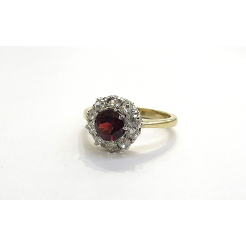 6302 - An 18ct gold garnet and diamond cluster ring the central garnet framed by ten diamonds, 0.50ct total... 