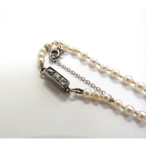 6120 - A graduated pearl necklace with a diamond set clasp, 58cm long