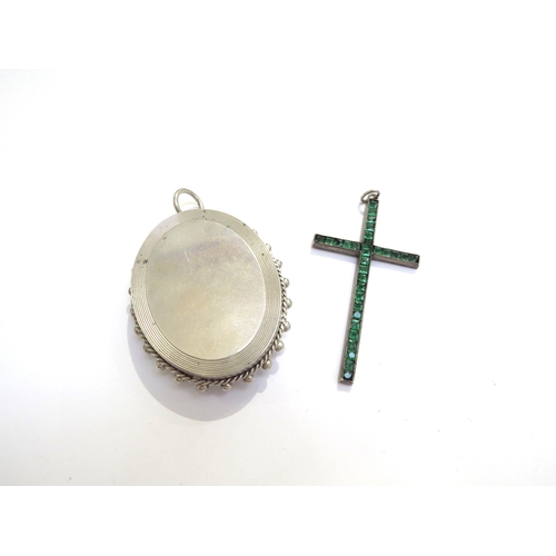 6414 - A Victorian engraved oval locket and a paste set cross