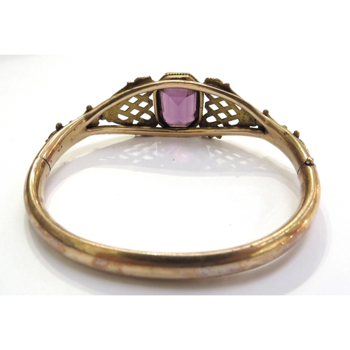 6310 - A Victorian gold filled Bates and Bacon bangle set centrally with an amethyst coloured stone with or... 