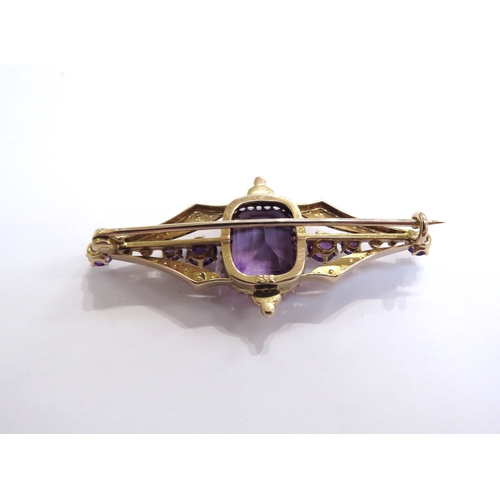 6267 - An amethyst and seed pearl brooch, the central amethyst 12mm x 9mm flanked by a further three amethy... 