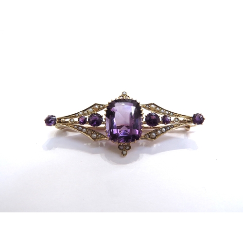 6267 - An amethyst and seed pearl brooch, the central amethyst 12mm x 9mm flanked by a further three amethy... 