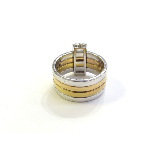 6263 - A tri colour gold ring with four bands, held together with a sliding diamond set buckle, the outer b... 