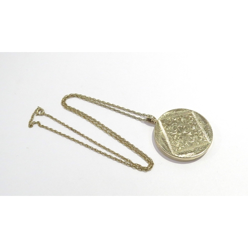 6047 - A 9ct gold circular locket engraved decoration to front, 3.5cm diameter, hung on unmarked chain, 13.... 