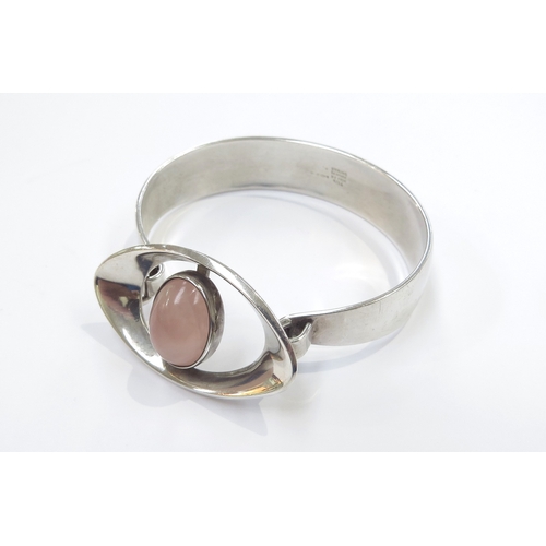 6411 - A Danish silver modernistic bangle by Niels Erik From with a rose quartz to an elliptical shape fron... 