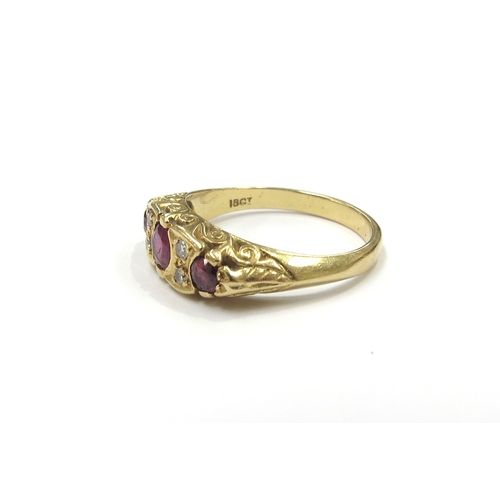 6027 - An 18ct gold ring set with three rubies spaced by old cut diamonds. Size P, 5.6g