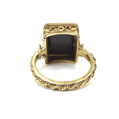 6163 - An unmarked gold ring with an intaglio depicting a bust of a Roman soldier, ornate scroll frame. Siz... 