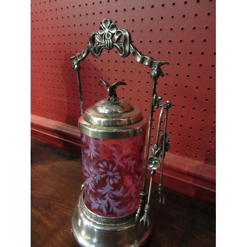 4022 - A silver plated and cranberry glass pickle castor with tongs, 30cm tall