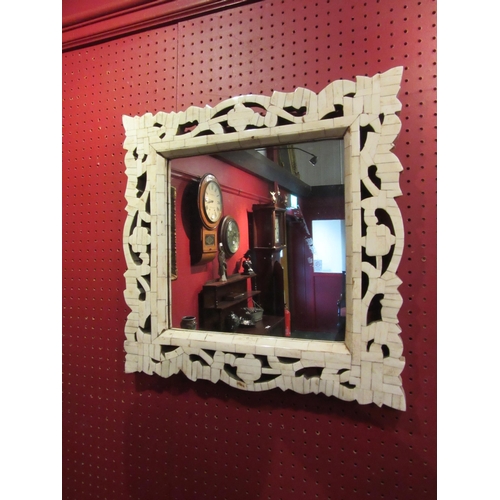 4027 - A bone effect framed wall mirror, 47cm x 47cm