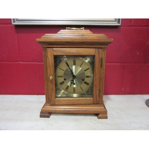 4115 - An oak cased bracket clock with Westminster chiming movement, with key and pendulum