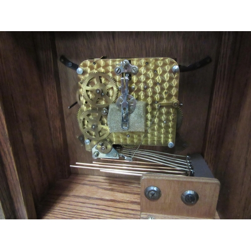 4115 - An oak cased bracket clock with Westminster chiming movement, with key and pendulum