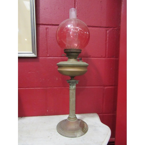 4116 - A Victorian copper and brass oil lamp with Corinthian column, cranberry glass