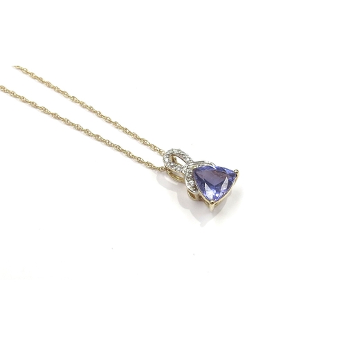 6151 - A gold pendant with a trillion cut tanzanite and white stones, stamped 10k, hung on a gold chain sta... 