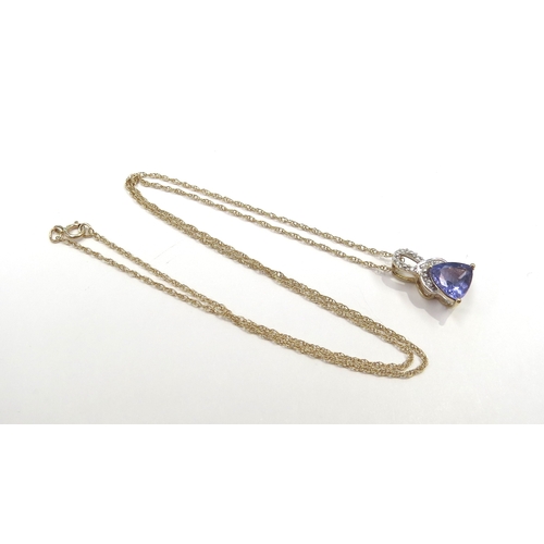 6151 - A gold pendant with a trillion cut tanzanite and white stones, stamped 10k, hung on a gold chain sta... 