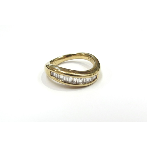 6264 - A gold ring set with a curve of baguette cut diamonds in channel setting, stamped 18k. Size N, 6.5g