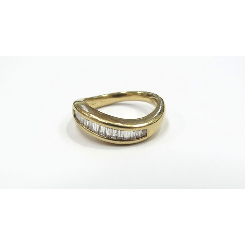 6264 - A gold ring set with a curve of baguette cut diamonds in channel setting, stamped 18k. Size N, 6.5g