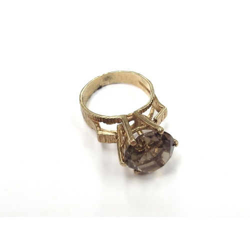 6311 - A 9ct gold ring set with a round cut smoky quartz in high claw mount. Size K, 4.5g