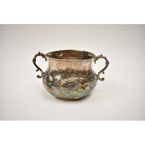 8069 - A Charles II provincial silver two handled porringer with embossed floral detail, 8.5cm tall, 9.7cm ... 