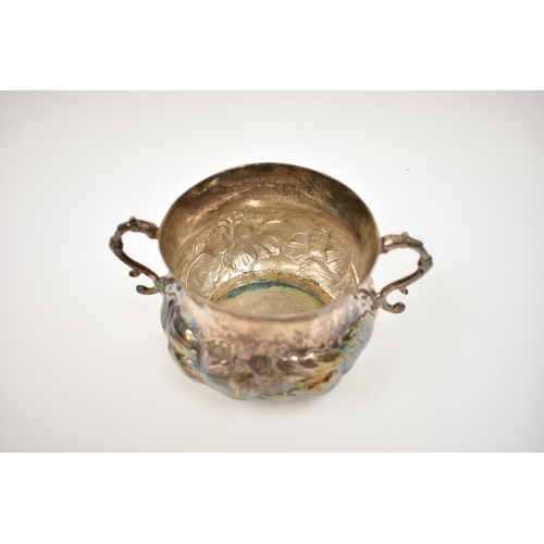 8069 - A Charles II provincial silver two handled porringer with embossed floral detail, 8.5cm tall, 9.7cm ... 