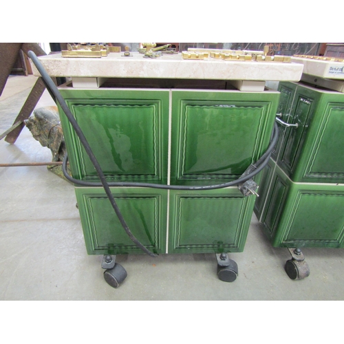 2024 - A pair of green glazed heaters on castors