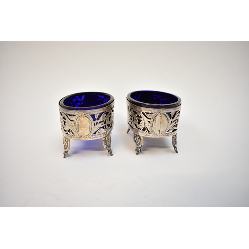 8087 - A pair of 18th Century white metal table salts with blue glass liners pierced floral and acanthus su... 