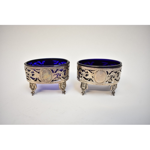 8087 - A pair of 18th Century white metal table salts with blue glass liners pierced floral and acanthus su... 