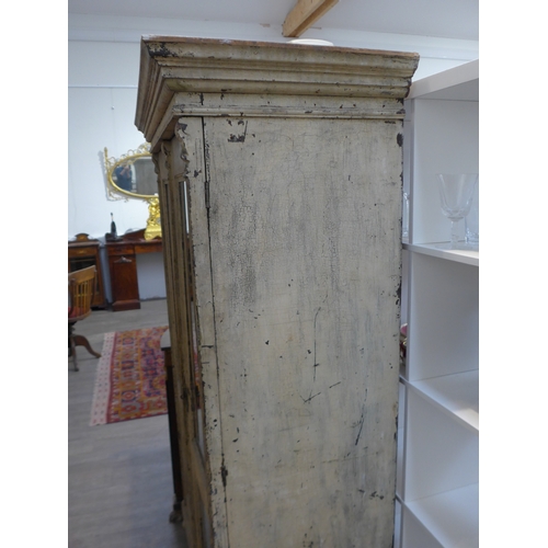 8484 - A French painted pine armoire the two glazed doors with key and shelved interior over turned feet, 1... 