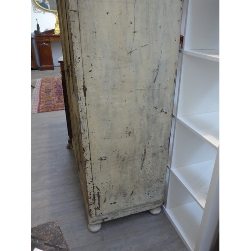 8484 - A French painted pine armoire the two glazed doors with key and shelved interior over turned feet, 1... 