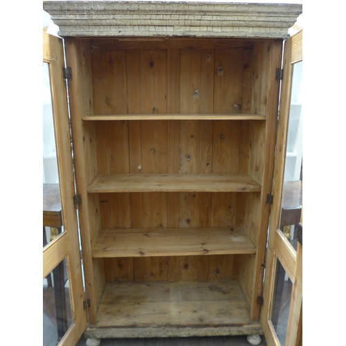 8484 - A French painted pine armoire the two glazed doors with key and shelved interior over turned feet, 1... 