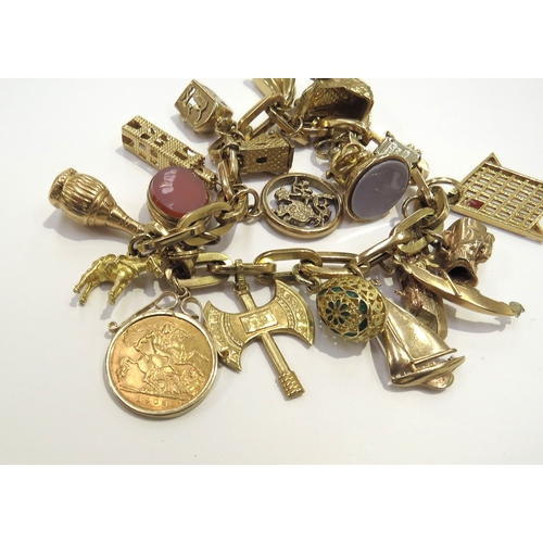 6387 - A charm bracelet stamped 750 hung with various gold charms including 18k, 9ct and a 1908 gold half s... 