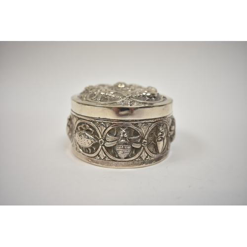 8032 - A white metal lidded trinket box, all-over repousse design of insects and creatures, 4cm tall x  8.7... 