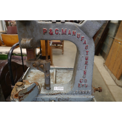 2056 - A cast iron button machine on stand by P.C Manufacturing Co. LTD, bolts missing