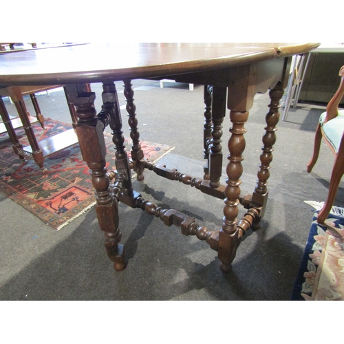 1086 - An 18th Century and later oak gateleg table the rising leaf oval top on cotton reel turned legs and ... 