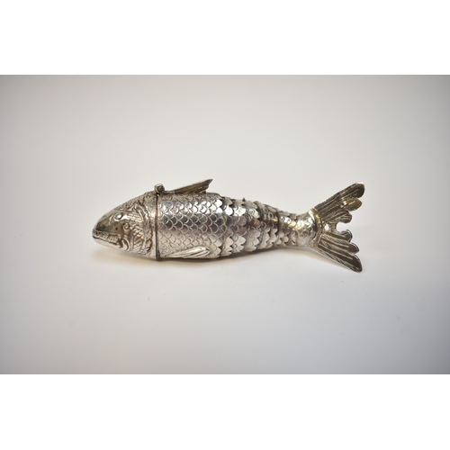 8023 - A white metal articulated fish pill pot, the sectioned ten piece body with hinged head opening to re... 