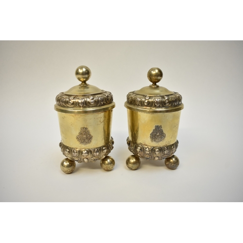 8082 - A pair of 17th/18th Century German silver gilt covered beakers, raised on three ball feet with Armor... 