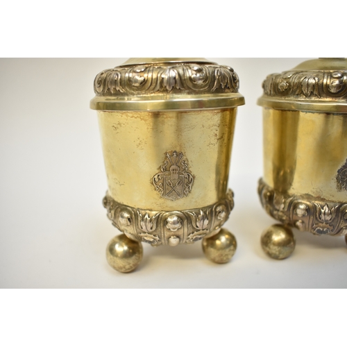 8082 - A pair of 17th/18th Century German silver gilt covered beakers, raised on three ball feet with Armor... 