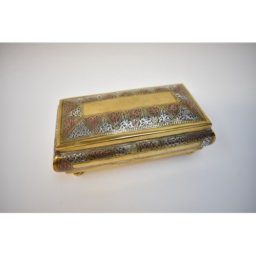 8107 - A box containing silver Alberts to include enamel and gold inlaid examples in Eastern brass casket (... 