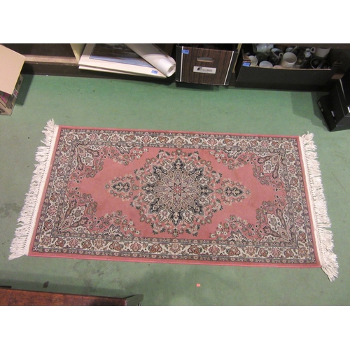 4003 - A Chinese rug in the Persian style, pink ground, tasselled ends, 150cm x 79cm