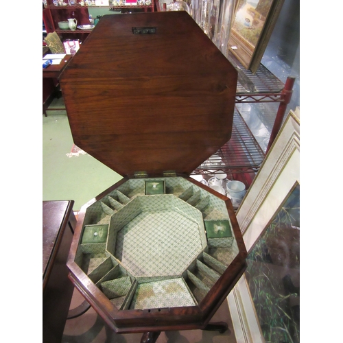 4012 - A Victorian burr walnut octagonal hinged top sewing table over a carved and turned column on a scrol... 