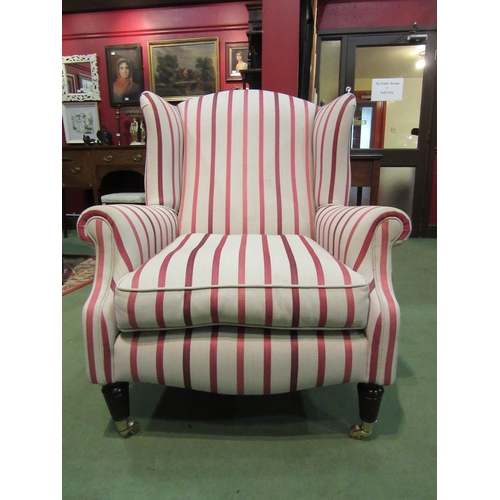 4069 - A George III style wingback armchair, the scroll arms over turned and reeded tapering fore legs on b... 