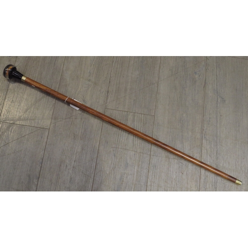 8611 - A walking cane with a knop containing  