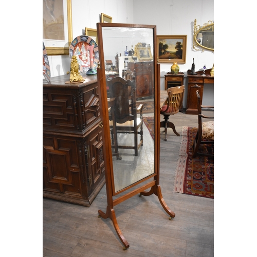 8485 - An early 20th Century mahogany full height Cheval mirror with outswept legs on brass castors, some d... 