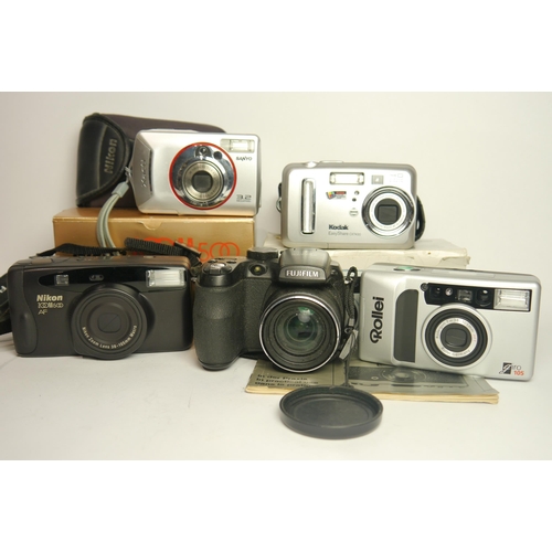 6083 - Two Boxed 35mm compact cameras & Three Digital cameras.
35mm Cameras: Nikon Zoom 500 Af 
Rollei Giro... 