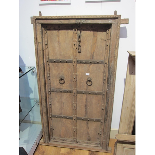 7453 - An Eastern hardwood door with metal detailing, 83cm(w) x 156cm(h)