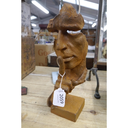 2059 - A cast iron abstract face figure 30cm tall