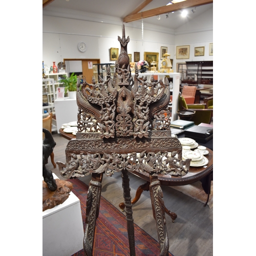 8616 - A highly ornate Thai carved wood easel decorated with flowers, figures and dragons.   77cm x 62cm