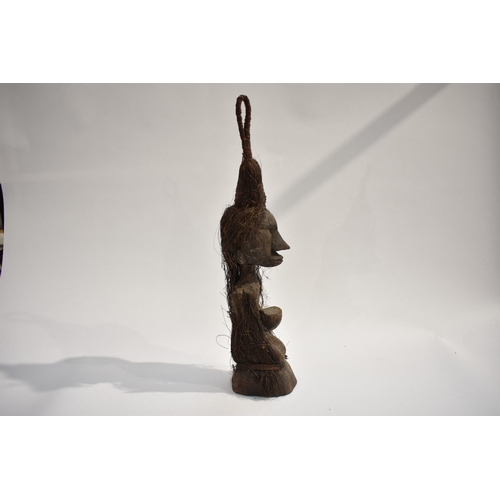 8618 - A Moluccas (Indonesia) type small carved wood ancestor figure, kneeling and holding a bowl with vege... 